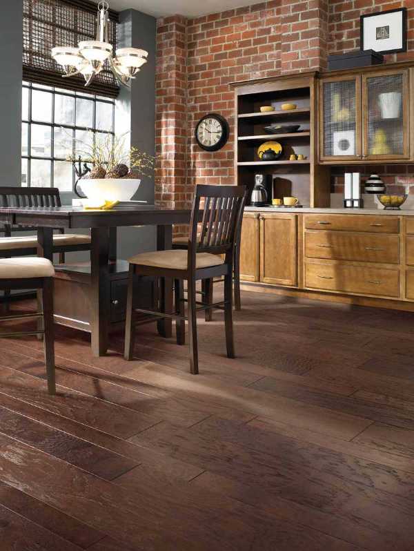 transitional dining room with dark wood floors an brick wall